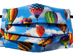 Blue fabric with multicoloured and varying sized hot air balloons pattern