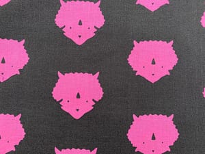 Dark grey fabric with silhouette print of pink triceratops head