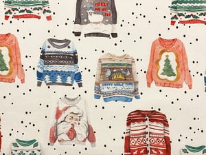 Cream coloured fabric with images of Christmas themed jumpers