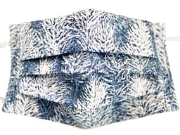 White and blue fabric mask closeup with wintry forest pattern
