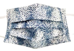 White and blue fabric mask closeup with wintry forest pattern