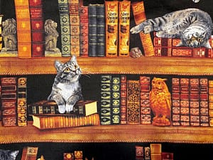 Black fabric with bookshelf and cats playing and sleeping pattern